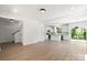 Open-concept living space with hardwood floors, a staircase, bright white walls, and seamless flow to the kitchen at 27 Mickley Ave, Bessemer City, NC 28016
