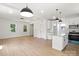 Open living area features hardwood floors, white walls, modern pendant lighting, and a kitchen island with granite countertops at 27 Mickley Ave, Bessemer City, NC 28016
