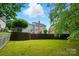 Lush backyard with a stone retaining wall and steps leading to a well-manicured lawn at 2725 Cotton Planter Ln, Charlotte, NC 28270
