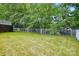 Spacious backyard featuring a well-maintained lawn, a white fence, and mature trees at 2725 Cotton Planter Ln, Charlotte, NC 28270