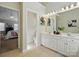 This bathroom features a dual vanity, decorative mirrors, tile floors, and doorway to the main bedroom at 2725 Cotton Planter Ln, Charlotte, NC 28270