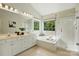Bright bathroom with dual vanity, soaking tub, glass-enclosed shower, and a large window with nature views at 2725 Cotton Planter Ln, Charlotte, NC 28270