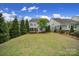 Spacious backyard with lush green lawn, mature trees, and a charming patio area perfect for outdoor relaxation at 295 Helton Ln, Fort Mill, SC 29708