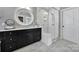 Bright bathroom featuring a glass-enclosed shower, vanity with a decorative mirror, and tile floors at 295 Helton Ln, Fort Mill, SC 29708