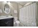 Cozy bathroom with a vanity, toilet, and a shower featuring a white curtain with ruffle details at 295 Helton Ln, Fort Mill, SC 29708