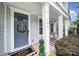 Inviting front porch with a blue door, decorative wreath, and a charming welcome mat, creating a warm entrance at 295 Helton Ln, Fort Mill, SC 29708