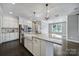 Bright open kitchen with stainless appliances, white cabinets, a large island with granite countertop, and modern pendant lighting at 295 Helton Ln, Fort Mill, SC 29708