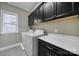 Well-organized laundry room with a front loading washer and dryer, black cabinets, and a countertop at 295 Helton Ln, Fort Mill, SC 29708