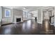 Open-concept living room featuring a fireplace, built-in cabinets, dark hardwood floors, and access to a wet bar at 295 Helton Ln, Fort Mill, SC 29708