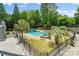 Backyard pool area with mature trees, stone patio, lounge seating and hot tub at 2971 Kaneland Ct, Rock Hill, SC 29732