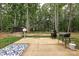 Backyard patio with barbeque grill and outdoor seating near a wooded lot at 3020 Quiet Ln, Iron Station, NC 28080