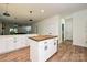 Open kitchen area with bright white cabinets, butcher block island and view to living area at 3020 Quiet Ln, Iron Station, NC 28080
