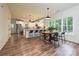 Bright, open kitchen flows into a dining area with a wooden table and large windows showcasing the natural surroundings at 3020 Quiet Ln, Iron Station, NC 28080