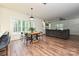 Open-concept living area with wood floors, large windows, a dining table and a comfortable sofa at 3020 Quiet Ln, Iron Station, NC 28080