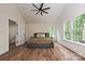 Spacious main bedroom featuring a ceiling fan, hardwood floors, and natural light from large windows at 3020 Quiet Ln, Iron Station, NC 28080