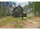 Exterior shot of the rear of the house featuring a patio, grill and wooded scenery at 3020 Quiet Ln, Iron Station, NC 28080