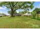 Large backyard with mature tree, partial fence, shed, and home in the background at 3103 Suggs St, Belmont, NC 28012