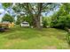 Spacious backyard featuring a mature tree, small storage shed, and partial fencing at 3103 Suggs St, Belmont, NC 28012