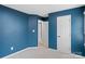 Bedroom with carpeted floors, blue walls, and multiple doors at 3103 Suggs St, Belmont, NC 28012