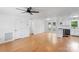 Open living room featuring hardwood floors, white walls, a ceiling fan and access to the updated kitchen at 3103 Suggs St, Belmont, NC 28012