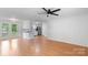 Bright living room with hardwood floors and access to kitchen; features a ceiling fan and white walls at 3103 Suggs St, Belmont, NC 28012