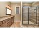 Modern bathroom features a tiled shower with a glass door, granite countertops, and wood cabinets at 3105 Bonterra Blvd, Indian Trail, NC 28079