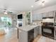 Modern kitchen featuring gray cabinets, an island, and views into the living room with a fireplace at 3308 Selwyn Farms Ln # 2, Charlotte, NC 28209