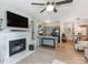 Cozy living room featuring a fireplace, TV, ceiling fan and an open layout to a modern kitchen with an island at 3308 Selwyn Farms Ln # 2, Charlotte, NC 28209