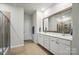 Bright bathroom featuring double sinks, white cabinets, and a shower at 3833 Isenhour Rd, Kannapolis, NC 28081