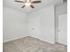 This bedroom features neutral carpeting and paint, a ceiling fan, and a closet with double doors at 3833 Isenhour Rd, Kannapolis, NC 28081