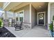 Inviting front porch featuring rocking chairs, stone pillar accents, and a decorated glass front door at 3833 Isenhour Rd, Kannapolis, NC 28081