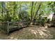 Backyard with wooden ramp leading to deck area, surrounded by lush greenery and mature trees at 4417 Walter Nelson Rd, Mint Hill, NC 28227