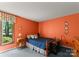 Inviting bedroom with warm orange walls, a cozy bed, and natural light from the window at 4417 Walter Nelson Rd, Mint Hill, NC 28227