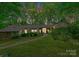 Evening view of wood and stone home, surrounded by trees and mature landscaping at 4417 Walter Nelson Rd, Mint Hill, NC 28227