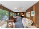 Living room with wood paneling, carpet flooring, large windows, and diverse seating options at 4417 Walter Nelson Rd, Mint Hill, NC 28227