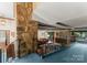 Open-concept living area with stone accent wall, exposed beams, and an adjacent balcony at 4417 Walter Nelson Rd, Mint Hill, NC 28227
