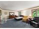 Bright bedroom with carpet flooring, multiple windows, and comfortable seating area with a dresser at 4417 Walter Nelson Rd, Mint Hill, NC 28227