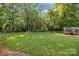Expansive grassy backyard with mature trees, a trampoline, and a secure fenced perimeter at 4622 Cotton Creek Dr, Charlotte, NC 28226