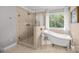 Beautiful bathroom featuring a glass-enclosed shower and a soaking tub with elegant fixtures at 4622 Cotton Creek Dr, Charlotte, NC 28226