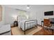 Cozy bedroom with a metal frame bed, hardwood floors, and a dedicated desk area at 4622 Cotton Creek Dr, Charlotte, NC 28226