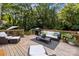 Expansive wooden deck features a grill, outdoor seating, and a peaceful view of the tree-lined backyard at 4622 Cotton Creek Dr, Charlotte, NC 28226