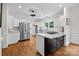Modern kitchen with a center island, stainless steel refrigerator, and hardwood floors at 4622 Cotton Creek Dr, Charlotte, NC 28226
