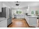 Well-lit kitchen with white cabinets, stainless steel refrigerator, hardwood floors, and white subway tile backsplash at 4622 Cotton Creek Dr, Charlotte, NC 28226