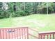 Large backyard view from the deck, featuring a manicured lawn and lush green trees at 517 N Pine Ln, Wadesboro, NC 28170