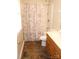 Cozy bathroom featuring a tub/shower, a neutral shower curtain, wood cabinets and vinyl flooring at 517 N Pine Ln, Wadesboro, NC 28170