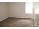 Cozy bedroom with plush carpeting and a bright window, providing natural light and a comfortable atmosphere at 517 N Pine Ln, Wadesboro, NC 28170