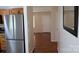 Hallway showcasing stainless steel fridge, with hardwood floors leading to other rooms at 517 N Pine Ln, Wadesboro, NC 28170