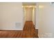 Long hallway featuring hardwood floors and neutral walls providing access to multiple rooms at 517 N Pine Ln, Wadesboro, NC 28170