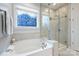 Bathroom features a soaking tub, walk-in glass shower, and decorative window at 528 Sandbar Pt, Clover, SC 29710