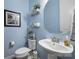 Stylish powder room with blue walls, wall art, mirror, and pedestal sink at 528 Sandbar Pt, Clover, SC 29710